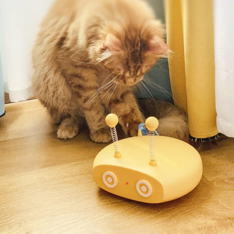 A cat playing with a yellow Cat Teasing Robot Laser Toy