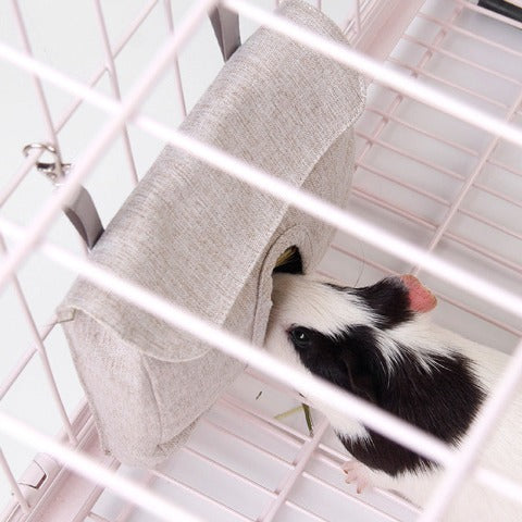 Guinea pig eating in a grey Pet Food Bag in a cage