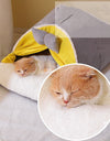 A cat sleeping in a milky yellow cozy cat cocoon